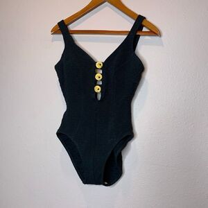 Mainstream vintage one-piece swimsuit features a textured fabric and gold button